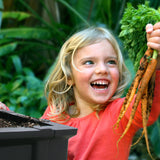 Girl pulling carrots from a Vegepod
